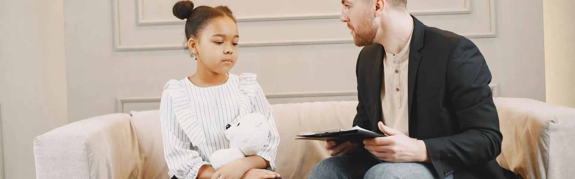 Profesional conversando con una niña durante una consulta