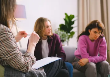 Pareja conversando con un profesional en consulta